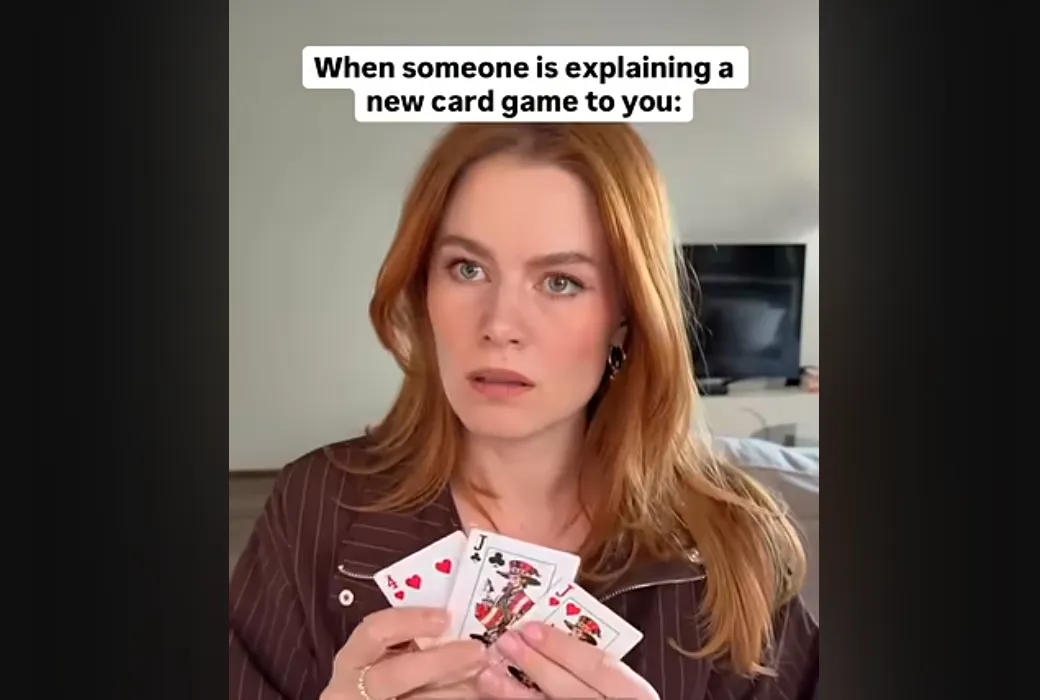 Meme of someone holding their cards the wrong way around with the text "When someone is explaining a new card game to you:"